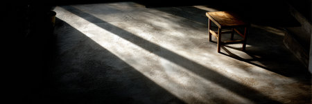 A single sunbeam cuts through the shadows, casting light on a terrace floor and highlighting a wooden chair in a tranquil afternoon setting.の素材