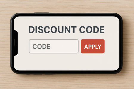 A smartphone display features a discount code input and apply button on a light wooden surface, suggesting online shopping.の素材