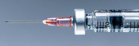 Close-up of a syringe preparing for an injection, displaying a clear empty zone at the top and a fine needle ready for use.の素材