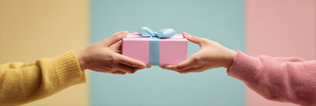Two hands exchange a beautifully wrapped gift embellished with a ribbon against a vibrant pastel backdrop, capturing the spirit of giving and celebration.の素材