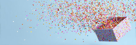 A vibrant explosion of confetti emerges from an open gift box, filling the air with joy and excitement perfect for celebrations and special occasions.の素材