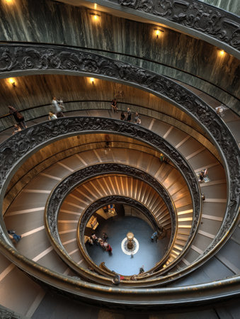 View from above of the ornate spiral staircase at Vatican Museums, showing its elegant architecture and visitors navigating the unique design in daylight.の素材