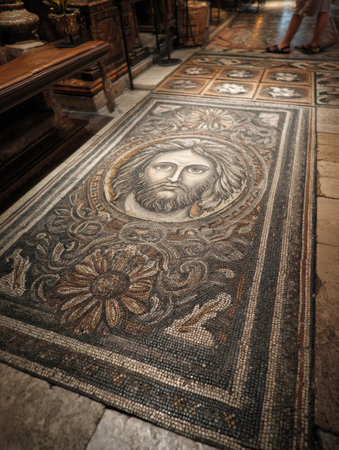 Detailed mosaic artwork featuring a face and floral patterns on the floor of the Vatican basilica, showing historical craftsmanship and gradual fading.の素材