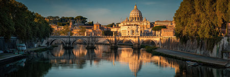 Evening light casts a warm glow on St. Peters while the Tiber River reflects the historic architecture and peaceful atmosphere of the scene.の素材