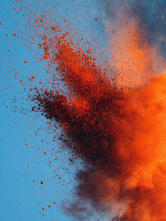 An energetic splash of sindoor powder fills the air in a striking display, contrasting beautifully with the serene blue sky during a cultural celebration.の素材