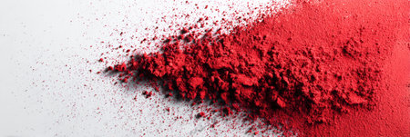 Vibrant red powder is scattered across a mirror surface, creating an artistic splash and contrasting sharply with the clean white margin on the side.の素材