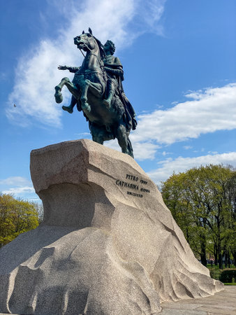 Monument to Peter the Great stands proudly on a large rock formation in Saint Petersburg, showcasing the statue against a bright blue sky and lush greenery.の写真素材