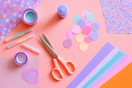 A vibrant DIY craft table features scissors, glue, pastel paper, and decorative materials, perfect for artistic activities and creative exploration.の素材