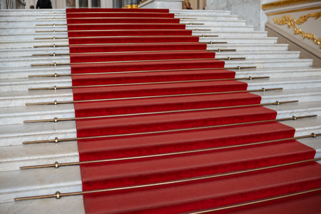 The staircase boasts a luxurious red carpet on marble steps, with polished brass rods adding grandeur for official gatherings.の写真素材