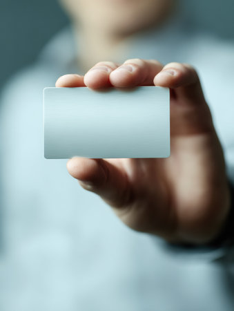 Fingers grip a blank card, showcasing an intimate moment with focus on identity and potential, set against a softly blurred background.の素材