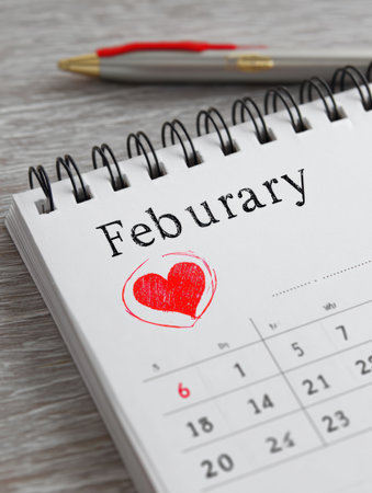 A calendar page for February shows the month clearly labeled with a hand-drawn heart circled on the 6th, indicating a special day for love and connectionの素材