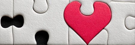Colorful puzzle pieces connect to form a heart with one piece missing in the upper zone, symbolizing lost connections and the search for completeness.の素材