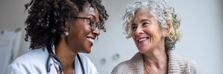 An older woman chats with a healthcare provider about important health topics during her wellness visit in a clinical setting.の素材