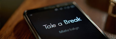 Glowing timer on a smartphone screen suggests taking a break, resting, or relaxing while placed on a wooden surface in a calm setting.の素材