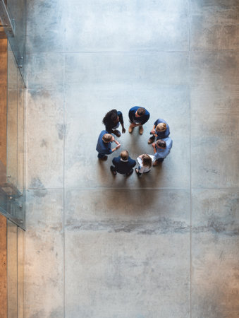 Group of individuals participating in a productive team meeting, discussing ideas and strategies in a well-organized workspace with clear surroundingsの素材