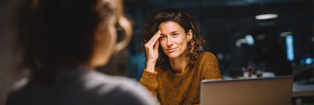 A therapist and patient discuss digital eye strain in a cozy, warmly lit office, focusing on comfort and understanding.の素材