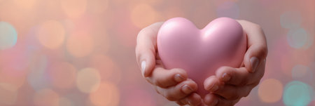 Hands gently cradle a soft 3D heart, emphasized against a warm pastel background, symbolizing affection and warmth in a serene setting.の素材