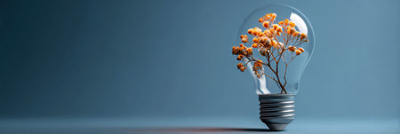 A lightbulb encases a blooming flower, representing innovation and growth. The minimalist backdrop accentuates the vibrant floral elements within.の素材