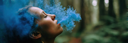 A person exhales blue wind in a tranquil forest, embodying peace and serenity amidst the lush greenery and towering trees, creating a magical atmosphere.の素材