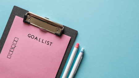 A motivational goal list sits on a sleek clipboard, accompanied by colorful pens, providing a structured space to outline personal aspirations and tasks.の素材