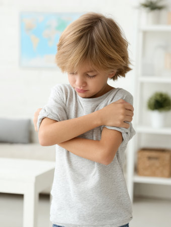 Young child exhibits proper hygiene by sneezing into their elbow during an appointment at the pediatricians office, surrounded by a welcoming atmosphere.の素材
