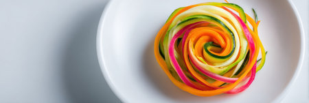 This vibrant veggie spiral showcases thinly sliced vegetables on a white plate, providing a fresh and healthy dining choice for any occasion.の素材