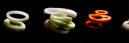 Colorful onion and pepper rings contrast vividly against a dark background, highlighting their shapes in a minimalist arrangement.の素材