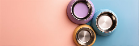 Colorful pet bowls arranged in an artistic layout against a soft pastel background, leaving open space for customization or text placements.の素材
