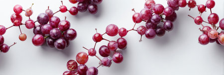 Grapes are creatively arranged in a molecular pattern on a soft white surface, highlighting the fruits texture and color in an artistic display.の素材