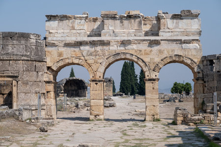 Visitors admire the ancient structures and unique landscape of Pamukkale, a UNESCO World Heritage site known for its rich history and thermal pools.の写真素材
