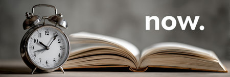 A clock with hands showing the current time sits next to an open book, representing the significance of embracing the present moment for personal growth.の素材