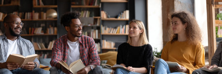Adults from various backgrounds participate in a collaborative language learning session using an app in a relaxed library space, sharing smiles and ideas.の素材