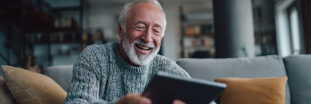 An elderly man with a joyful expression learns guitar while using a tablet in a comfortable living space filled with soft lighting and modern decor.の素材