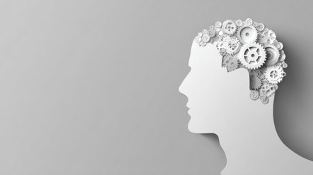 A silhouette of a human head features gears turning inside, symbolizing thoughts and creativity. The background is minimalistic and left mostly blank.の素材
