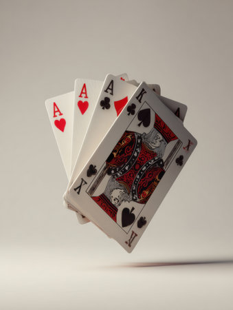 A detailed view of a poker hand featuring four aces along with a king of spades, captured with a neutral background for focus on the cards.の素材