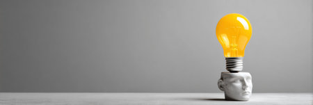 A vibrant lightbulb floats above a minimalist bust head, emphasizing the contrast between artistic form and illumination in a contemporary space.の素材