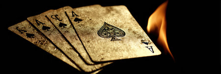 Golden playing cards burst from flames, highlighting the intricate spade designs as they emerge, creating a striking contrast against the dark surroundings.の素材
