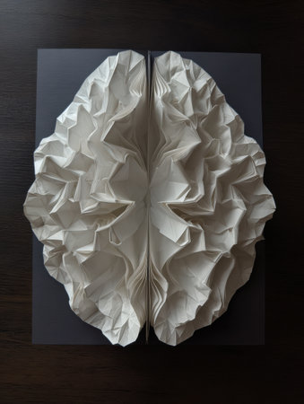 Intricate folded paper brain design unfolds into various pathways against a dark background, showing creativity and artistic expression.の素材