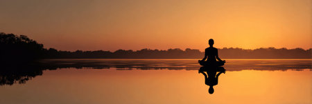 A tranquil lake reflects the beauty of a setting sun as a silhouette meditates peacefully, radiating warm inner light in a serene environment.の素材