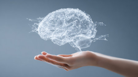 A detailed 3D model of a brain hovers above a hand, illustrating the connection between technology and human intelligence in an elegant, gradient setting.の素材