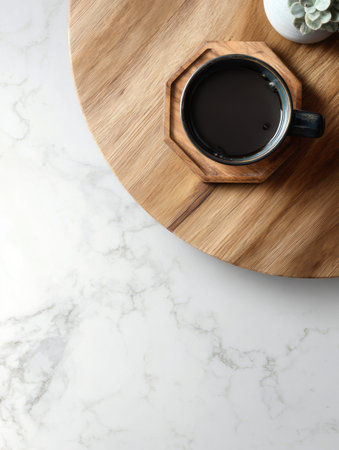 A clean wooden table showcases a half-empty mug resting on a coaster, surrounded by an open area and minimalistic decor, creating a serene atmosphere.の素材