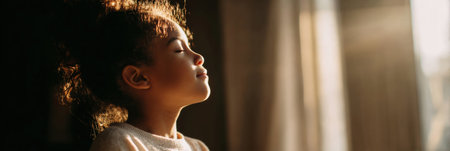 In a bright room filled with warm sunlight, a girl looks inspired after journaling, taking a moment to reflect with a peaceful expression and eyes closedの素材