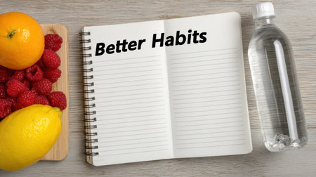 A notebook titled Better Habits sits next to vibrant fruit and a water bottle, with an open section ready for new ideas in a clean, bright workspace.の素材
