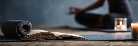 Student engages in meditation before studying, surrounded by a yoga mat and a lit candle, creating a serene atmosphere conducive to concentration.の素材