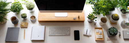 A high-angle view showcases a neat student workspace featuring various plants, a computer, and essential stationery organized for productivity.の素材