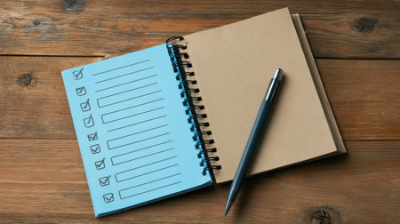 Open notebook features a checklist focusing on health, knowledge, relationships, and growth, resting on a rustic wooden surface with a pen nearby.の素材