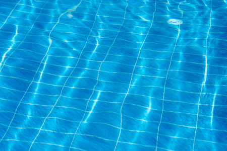 Clear turquoise water fills the swimming pool with sunlight creating shimmering reflections. Perfect...