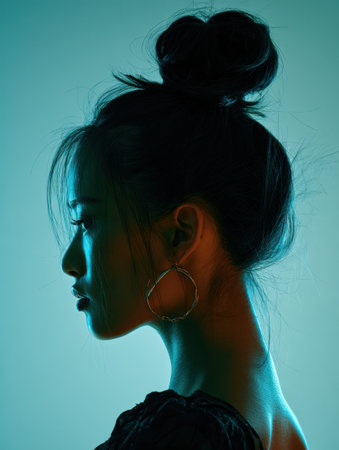 Portrait features a modern Asian hairstyle with a sleek updo, illuminated by soft lighting against a minimal gradient backdrop enhancing the subjects profile.の素材