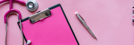 Plastic surgery certification displayed on a clipboard with a stethoscope and a pen arranged neatly on a pink surface in a healthcare settingの素材
