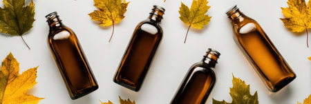 Amber glass bottles are artistically placed among vibrant yellow maple leaves, creating a striking autumn-themed composition.の素材